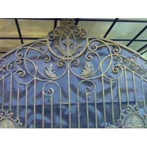 hand-made wrought iron gate with ornament and gold colour touch
